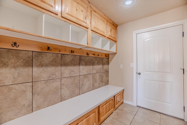 mudroom featuring a textured ceiling and light tile patterned floors