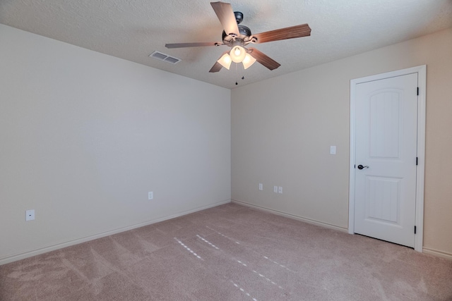 carpeted spare room with a textured ceiling and ceiling fan