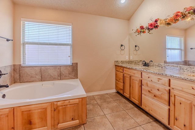 bathroom featuring a bath, a textured ceiling, lofted ceiling, tile patterned floors, and vanity