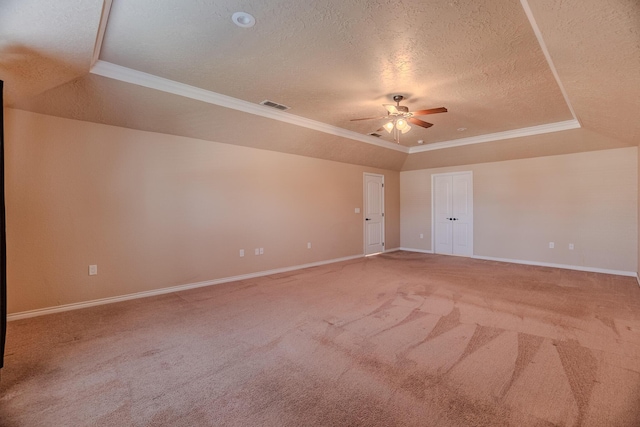 spare room featuring carpet, a tray ceiling, ceiling fan, a textured ceiling, and crown molding