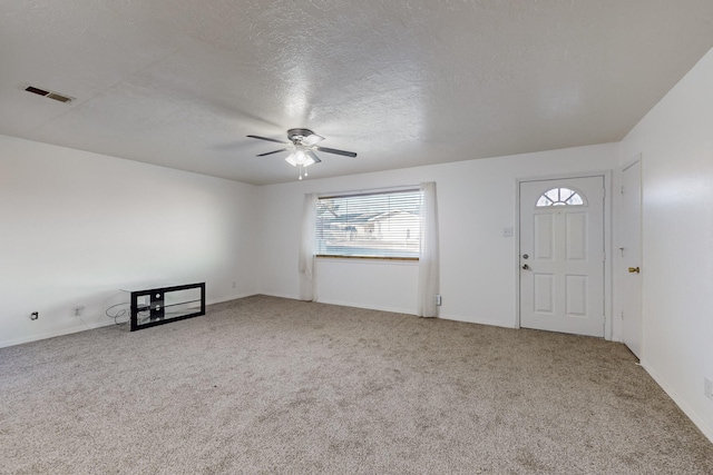 carpeted entrance foyer with ceiling fan and a textured ceiling