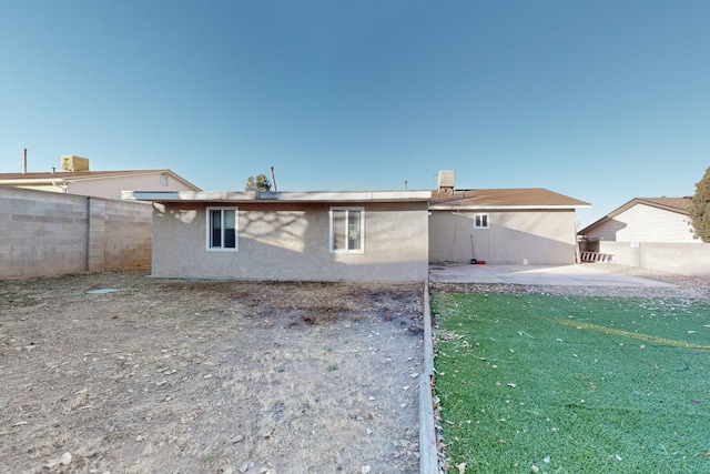 rear view of house with a yard and a patio