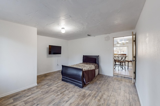 bedroom featuring an inviting chandelier and wood-type flooring