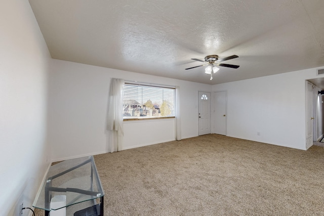 spare room with ceiling fan, carpet, and a textured ceiling