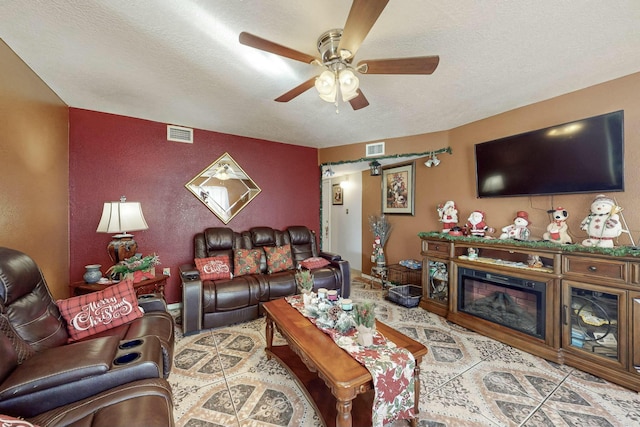 living room with ceiling fan and a textured ceiling