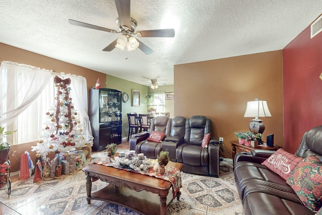 living room featuring ceiling fan and a textured ceiling