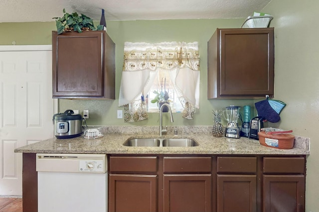 kitchen featuring dishwasher, a textured ceiling, and sink