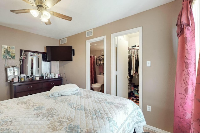 bedroom featuring ensuite bath, ceiling fan, a closet, and a walk in closet