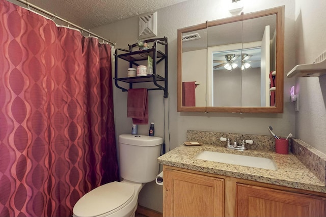 bathroom featuring ceiling fan, vanity, a textured ceiling, and toilet