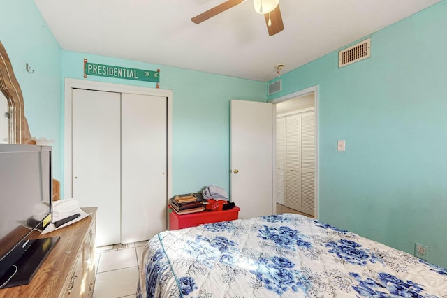 bedroom with ceiling fan, light tile patterned flooring, and a closet