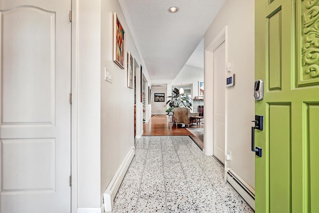 hall with a textured ceiling and a baseboard radiator