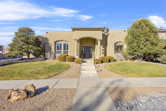 pueblo-style home with a front yard