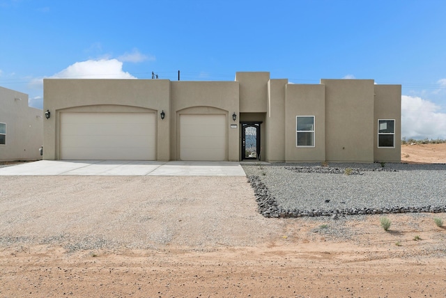 pueblo revival-style home featuring a garage