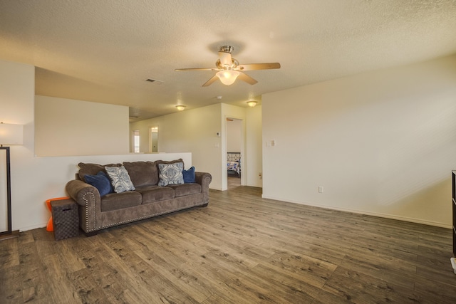 living room with ceiling fan, wood-type flooring, and a textured ceiling