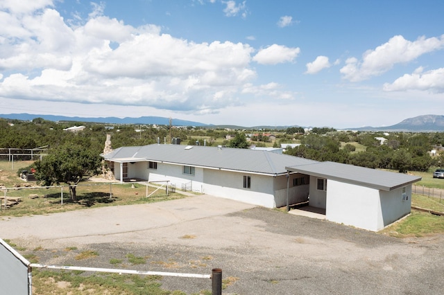 ranch-style home with driveway, metal roof, fence, a mountain view, and a carport