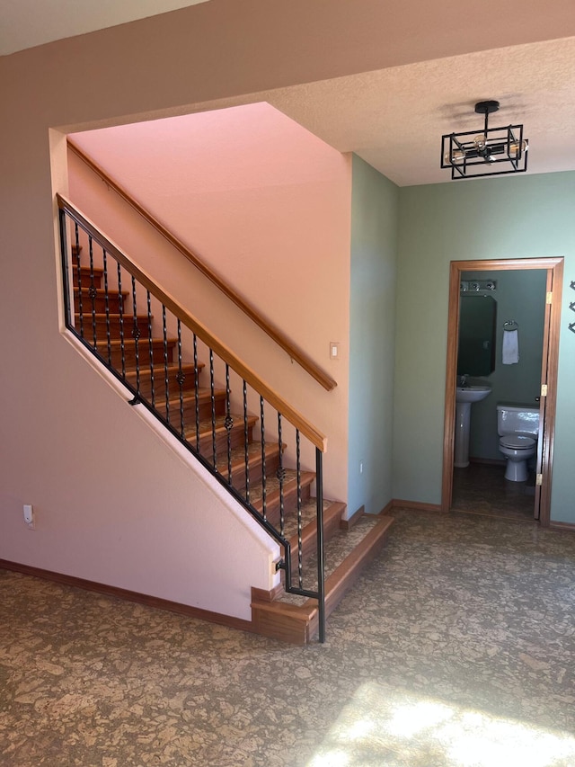 stairway with a notable chandelier