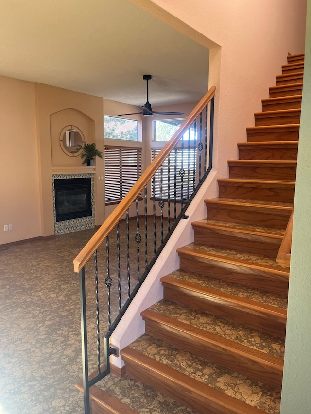 stairway featuring carpet floors and ceiling fan