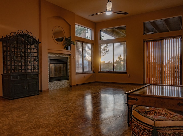 living room with ceiling fan and a tile fireplace