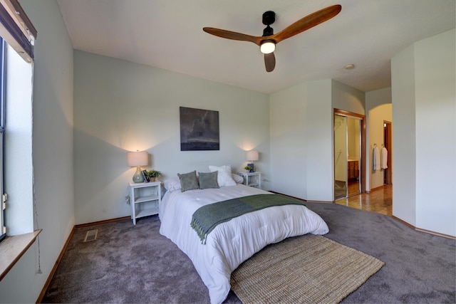 bedroom with dark colored carpet, ceiling fan, and a closet