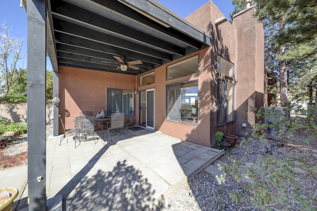 rear view of property with ceiling fan and a patio area