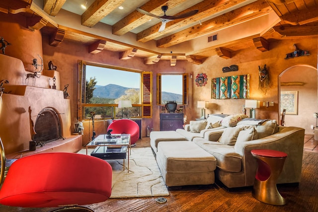 home theater room with beamed ceiling, wood-type flooring, and ceiling fan