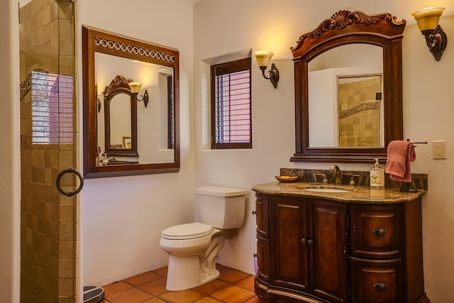 bathroom with toilet, vanity, tile patterned floors, and walk in shower