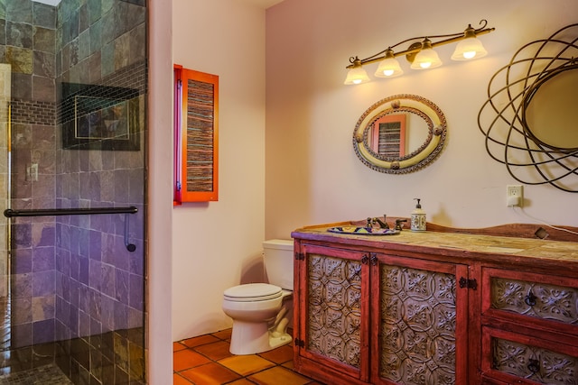 bathroom with tile patterned floors, vanity, toilet, and tiled shower