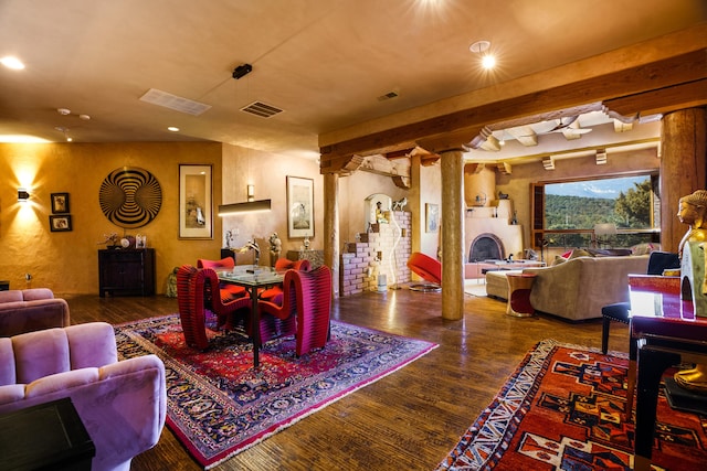 dining area featuring ornate columns and hardwood / wood-style floors