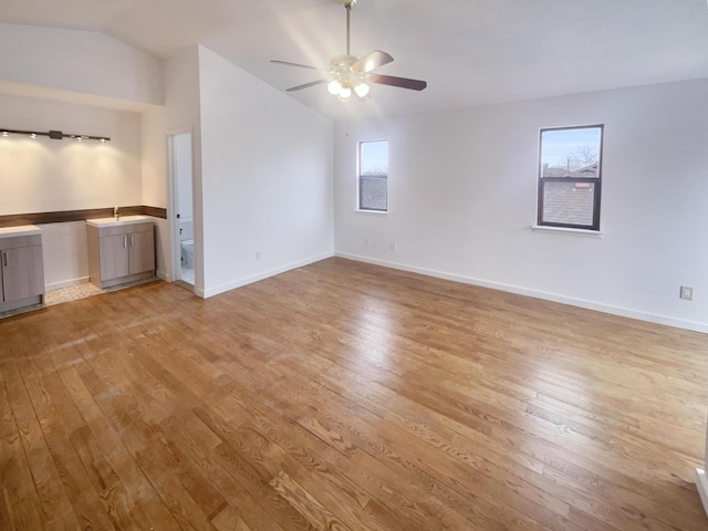 unfurnished room featuring ceiling fan, light hardwood / wood-style flooring, lofted ceiling, and sink