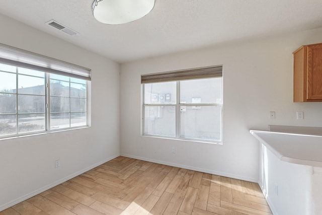 unfurnished dining area with light wood-type flooring