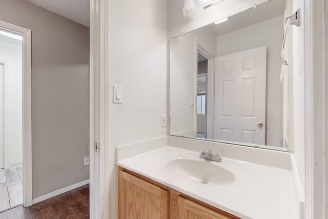 bathroom featuring hardwood / wood-style floors, vanity, and a textured ceiling