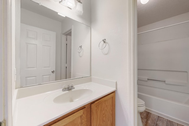 full bathroom with vanity, toilet, a textured ceiling, and bathtub / shower combination