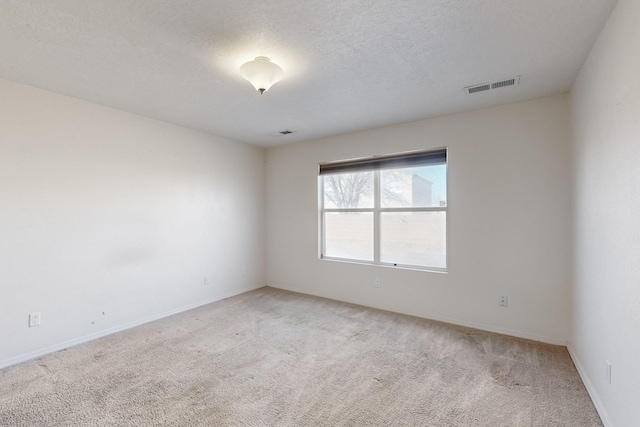 carpeted spare room featuring a textured ceiling