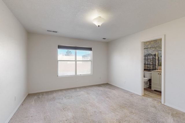 carpeted empty room with a textured ceiling