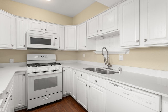 kitchen with white appliances, white cabinetry, dark hardwood / wood-style flooring, and sink