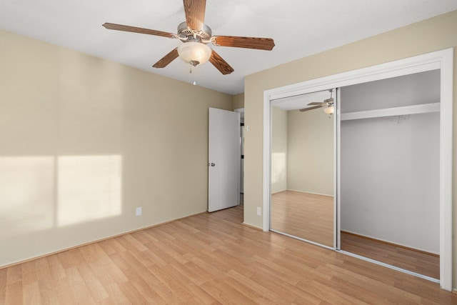 unfurnished bedroom featuring ceiling fan, light hardwood / wood-style flooring, and a closet