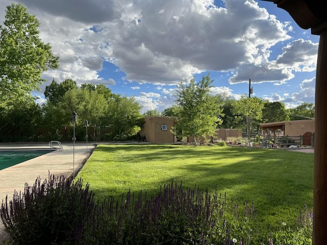 view of yard featuring fence and an outdoor pool