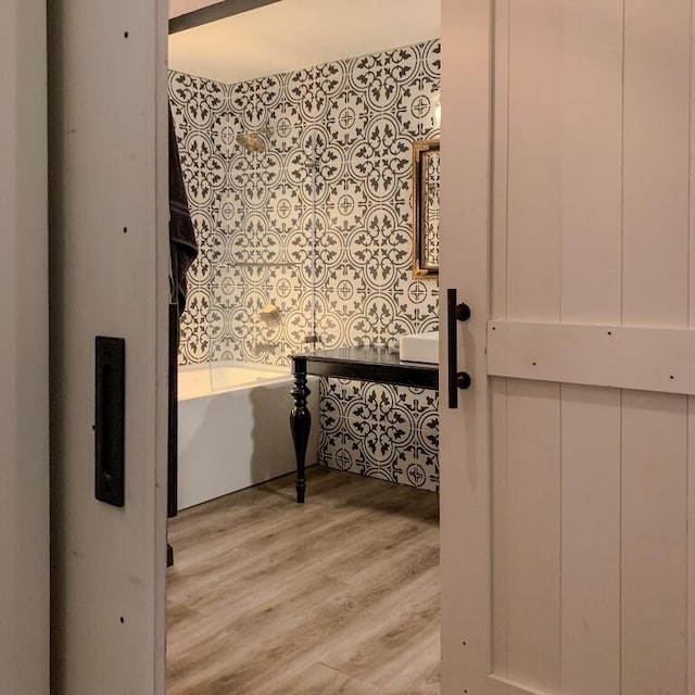 bathroom with a washtub and wood finished floors