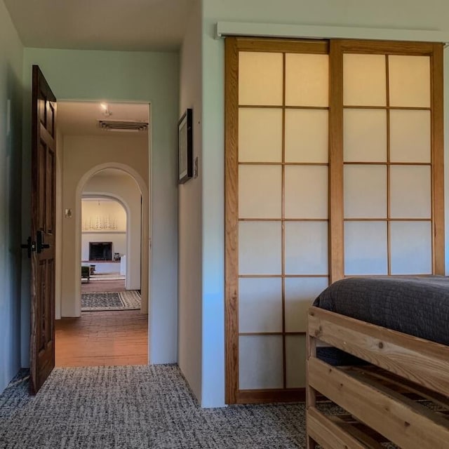 bedroom featuring arched walkways, wood finished floors, and visible vents