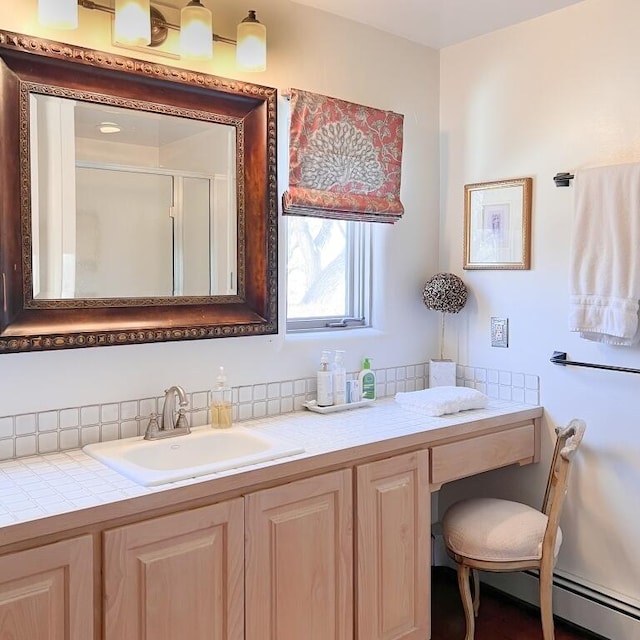 bathroom with a baseboard radiator, a shower stall, and vanity