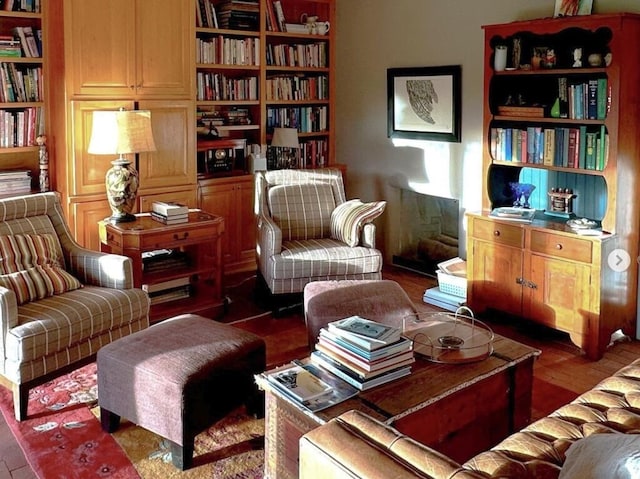 sitting room featuring wood finished floors and built in shelves