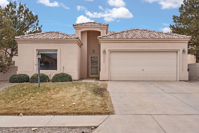 mediterranean / spanish-style house featuring a tile roof, stucco siding, a front yard, a garage, and driveway