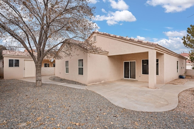 rear view of property featuring a patio area, a tiled roof, fence, and stucco siding