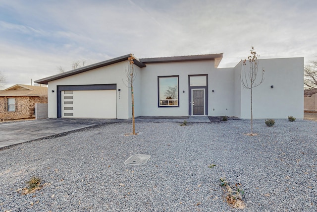 view of front of house with stucco siding, driveway, and an attached garage