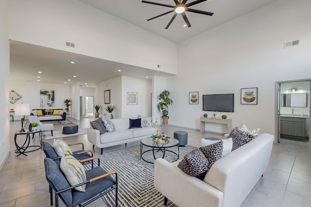 living area featuring visible vents, recessed lighting, a high ceiling, and a ceiling fan