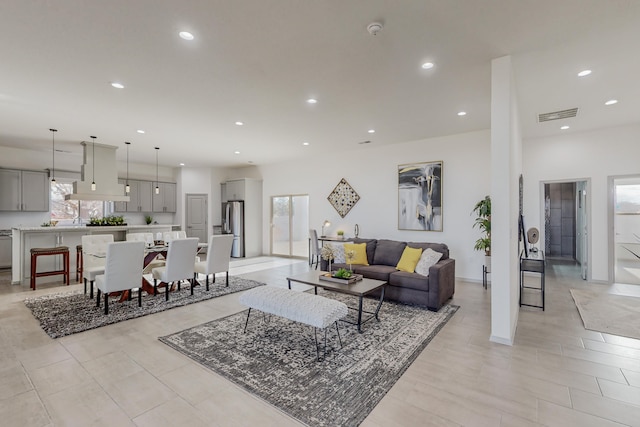 living area featuring recessed lighting, visible vents, and baseboards