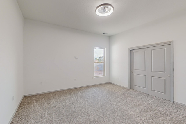 unfurnished bedroom with visible vents, baseboards, and light colored carpet