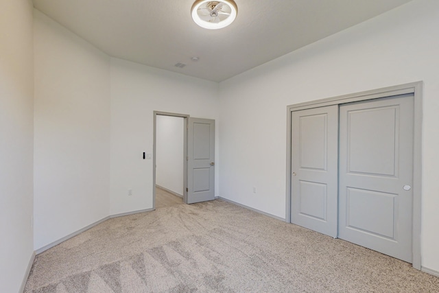 unfurnished bedroom with a closet, baseboards, and carpet floors