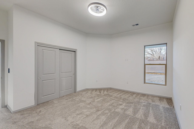 unfurnished bedroom featuring carpet, visible vents, and baseboards