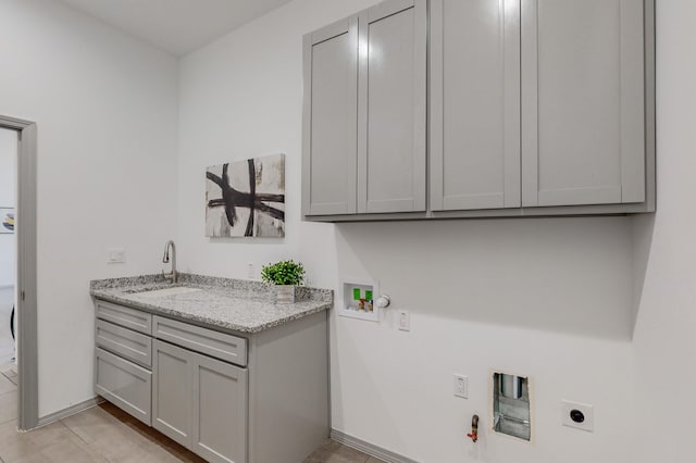 laundry area featuring hookup for an electric dryer, gas dryer hookup, cabinet space, a sink, and washer hookup